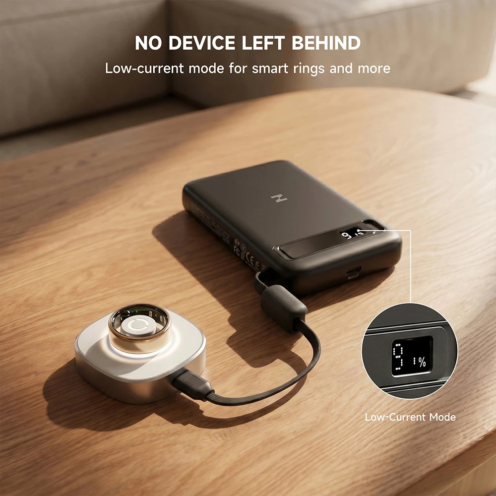 Black MagAir semi-solid-state magnetic power bank with a charging cable on a wooden surface, featuring low-current mode information. #color_black