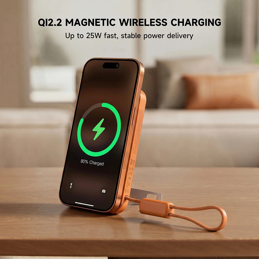 Orange MagAir magnetic wireless power bank charging a smartphone on a wooden surface with Qi2.2 magnetic wireless charging technology. #color_orange