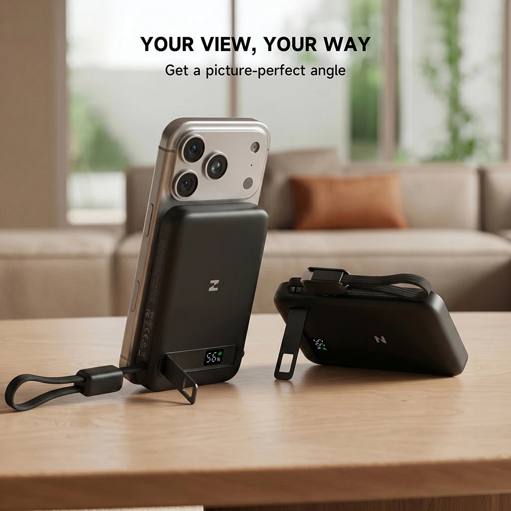 Smartphone with a MagAir magnetic power bank attached, placed on a table with a blurred indoor background. #color_black