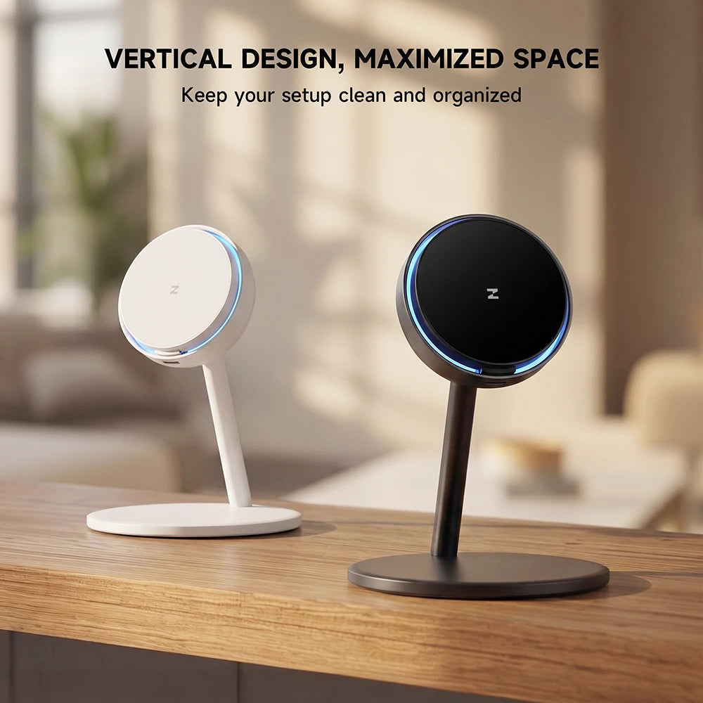 Two CoreDock wireless charging stands, one white and one black, featuring circular charging pads and slim vertical bases on a wooden table in a softly blurred indoor setting. #color_white