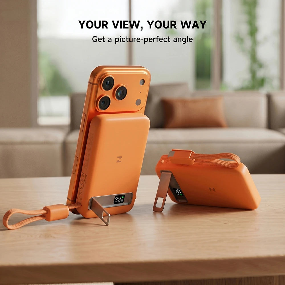 Two orange MagAir semi-solid-state power banks on a table with a blurred indoor background. #color_orange