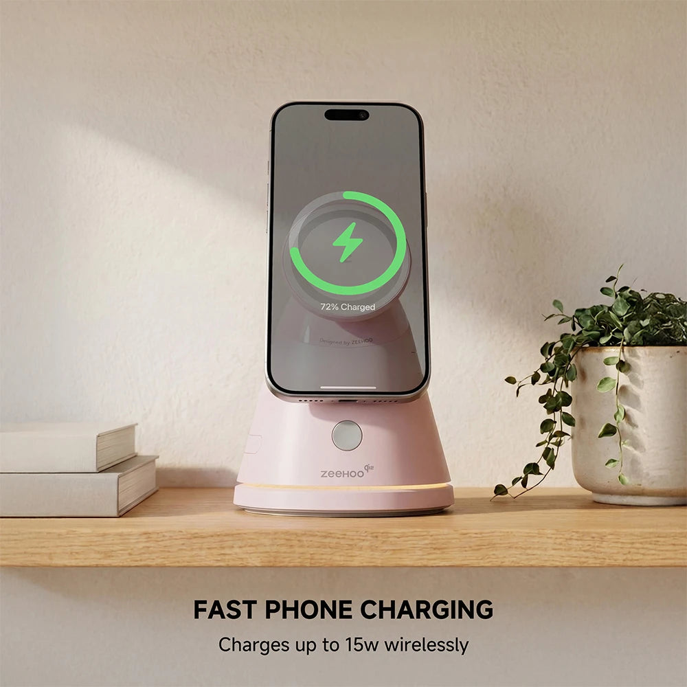 ZEEHOO LuminoCore pink 4-in-1 wireless charging stand holding a smartphone on a shelf, styled with books and a plant in a modern interior. #color_pink