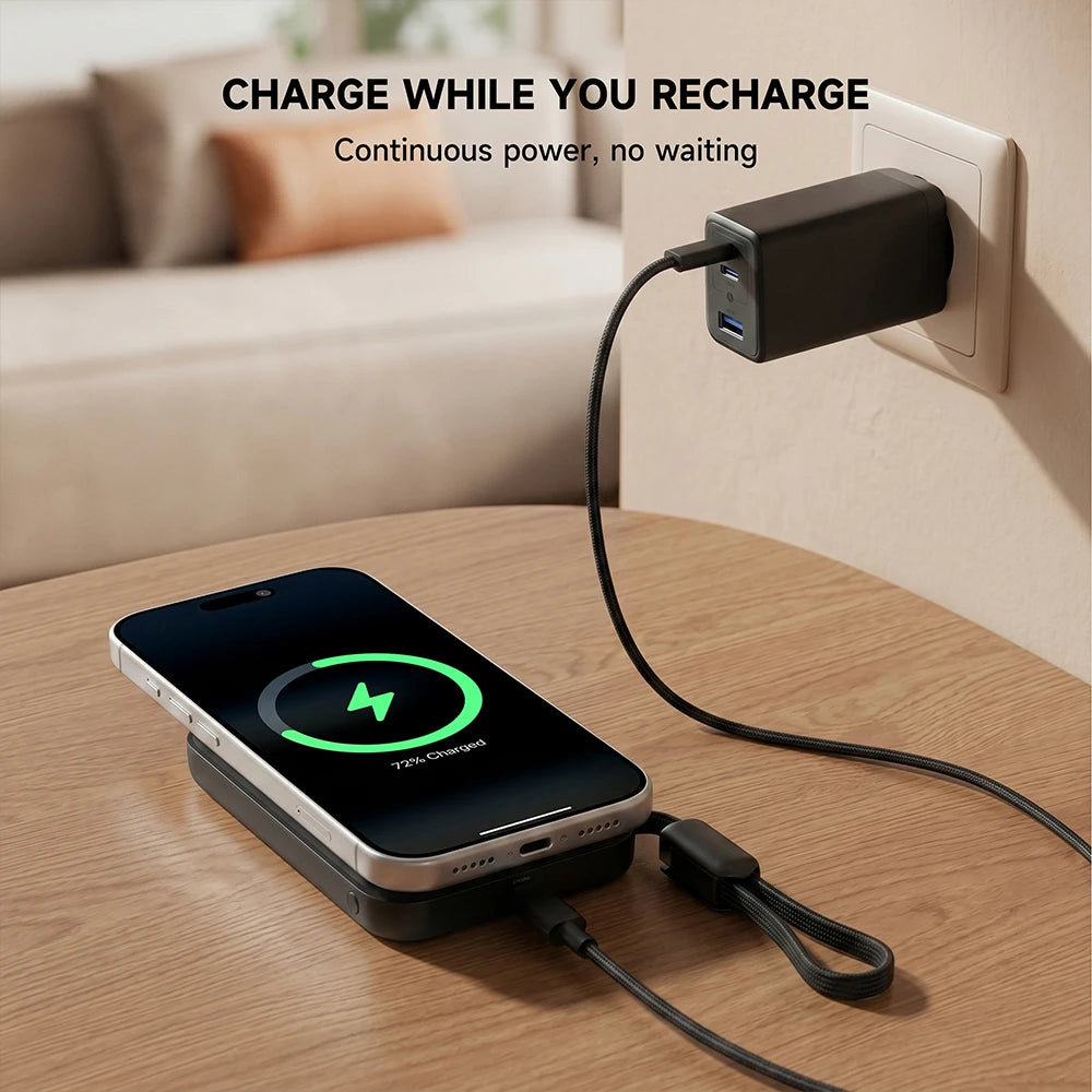 Black MagAir magnetic power bank charging a smartphone while connected to a power adapter in a home setting. #color_black