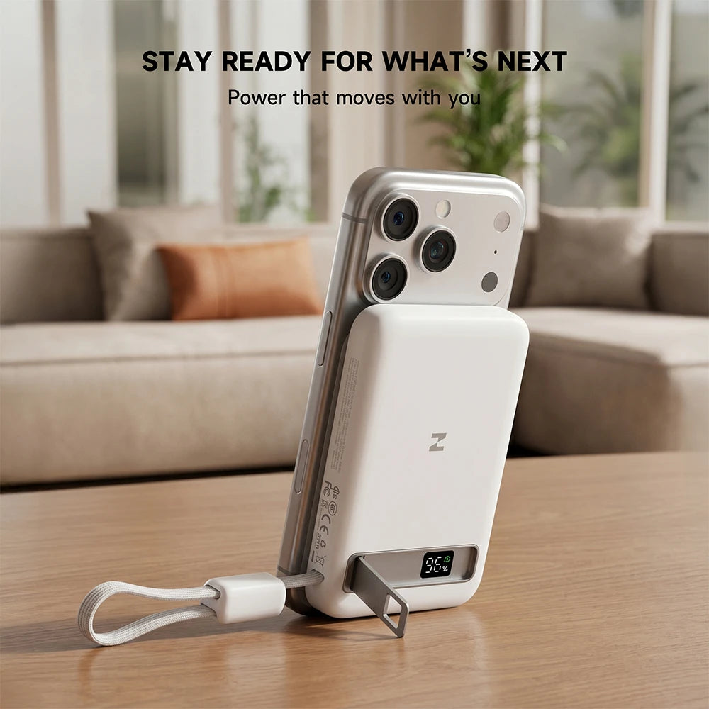 MagAir magnetic power bank attached to a smartphone case with a built-in stand on a table, featuring “Stay Ready for What's Next” text. #color_white