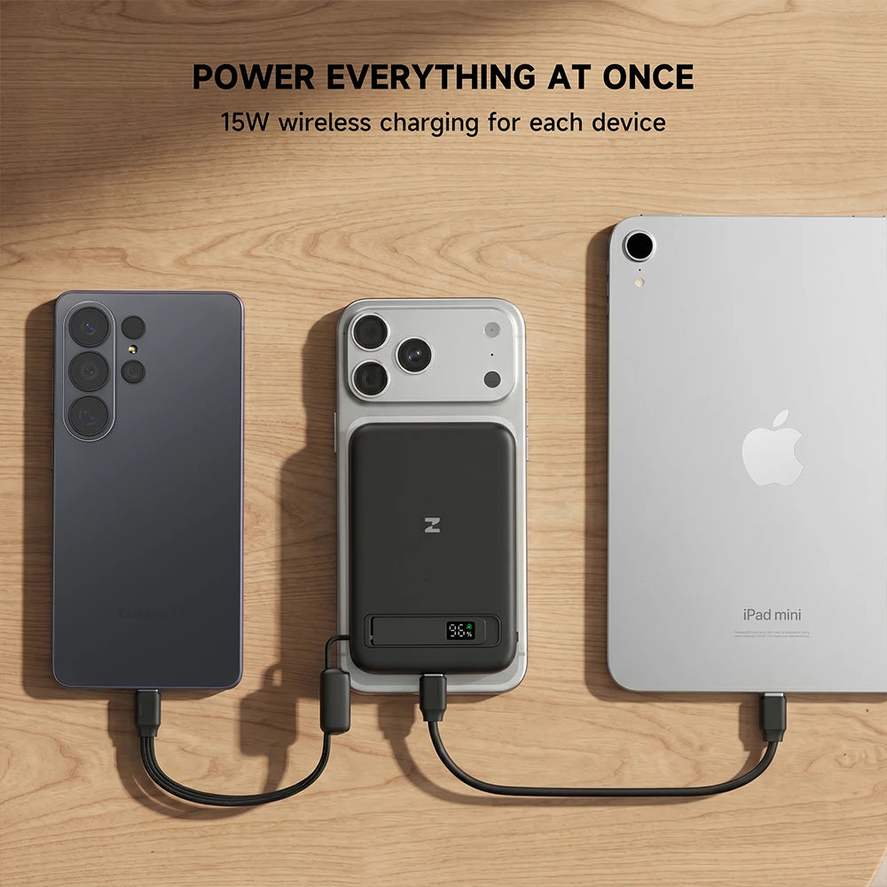 MagAir magnetic power bank charging multiple devices on a wooden surface. #color_black
