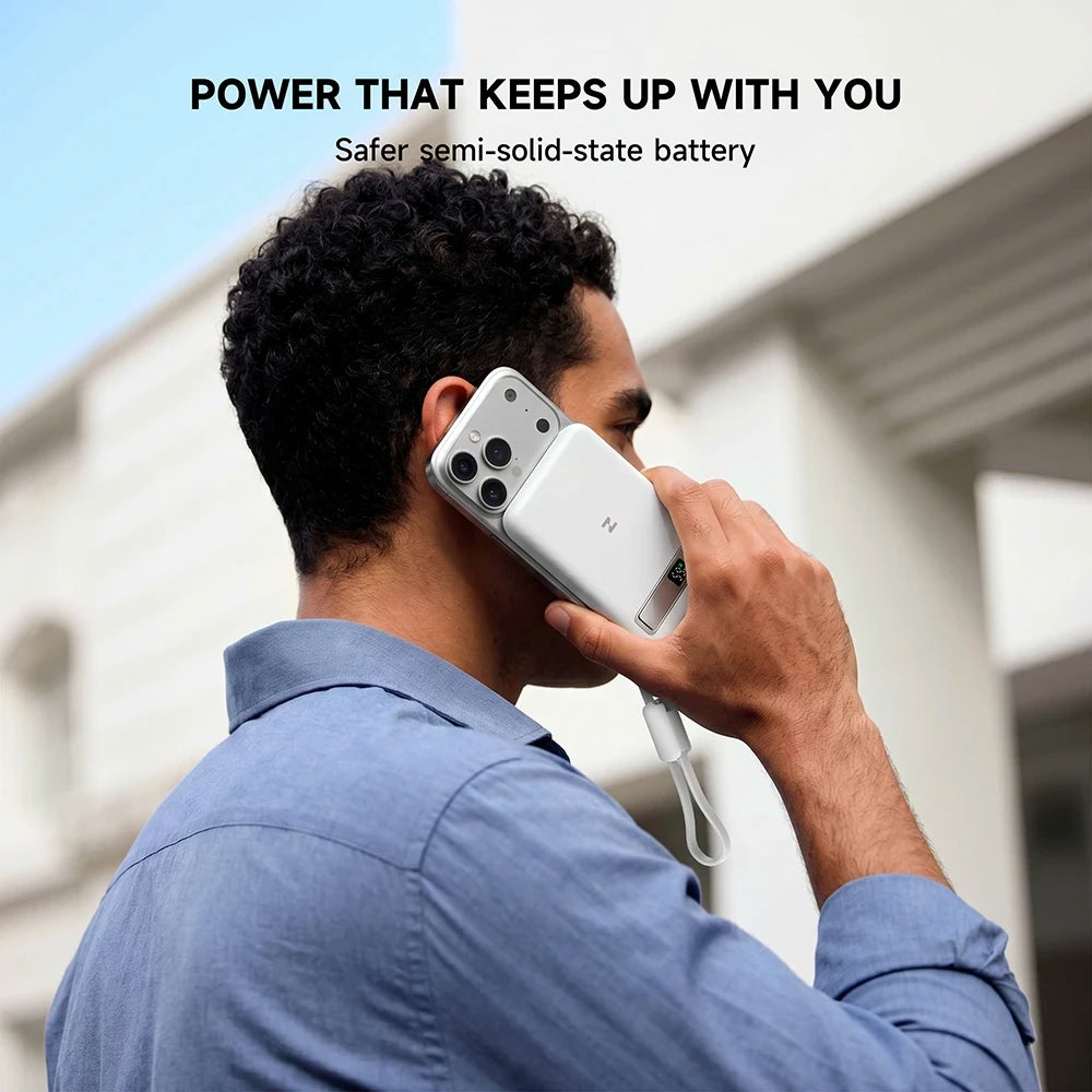 Person holding a smartphone with a white MagAir magnetic power bank, featuring battery capacity and safety information. #color_white