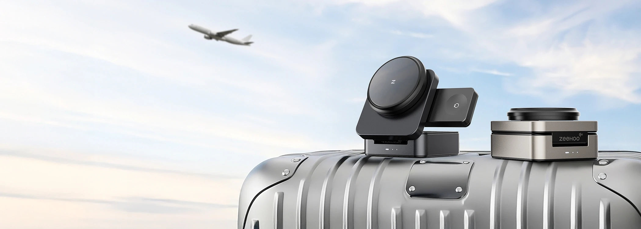 Two ZEEHOO FoldTrack wireless charging stands on a suitcase with a clear sky and an airplane in the background.