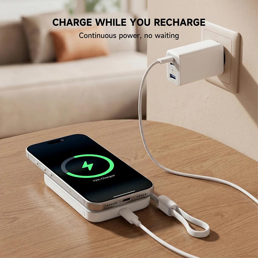 White MagAir magnetic power bank supporting pass-through charging, powering a smartphone while connected to a wall adapter on a wooden table. #color_white