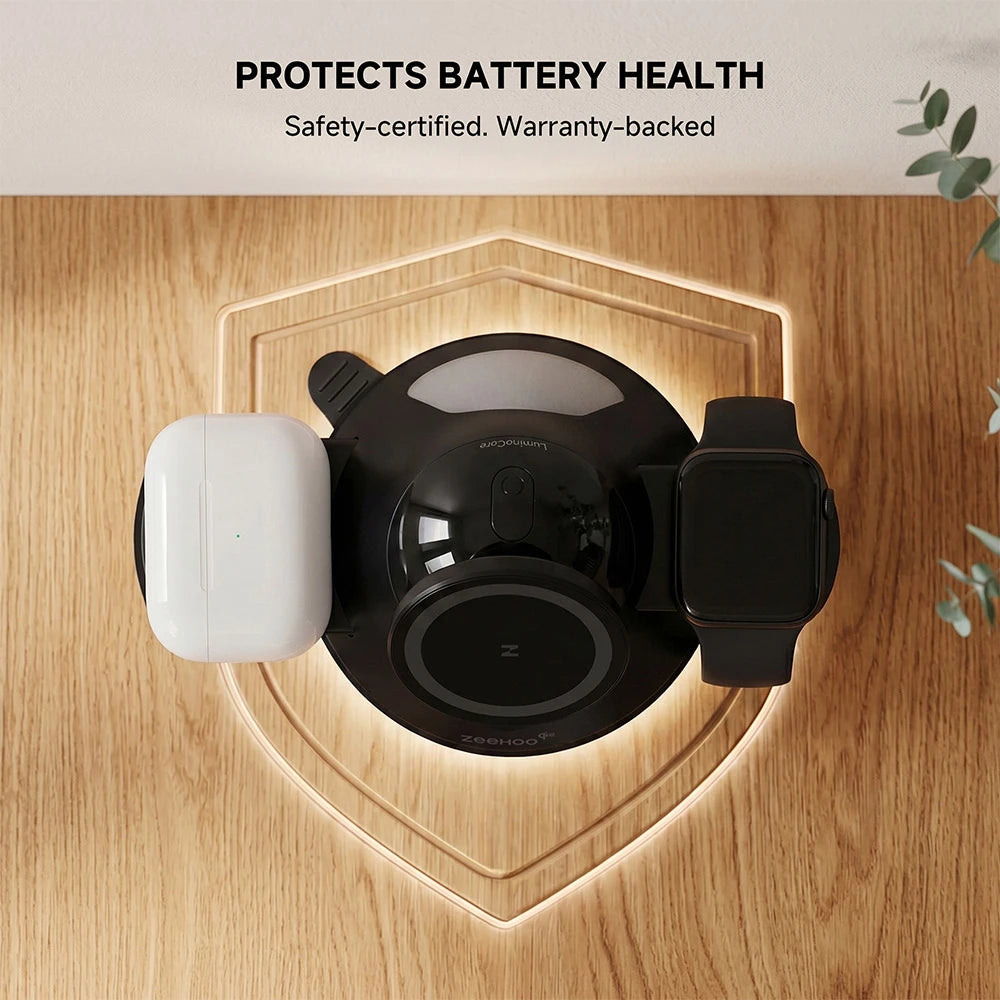 ZEEHOO LuminoCore black 4-in-1 wireless charging station on a wooden surface with smartphone, headphones, and smartwatch, optimized for battery health protection and safe charging. #color_black